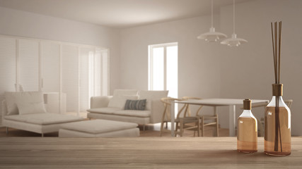 Wooden table top or shelf with aromatic sticks bottles over blurred scandinavian minimalist living room, white architecture interior design