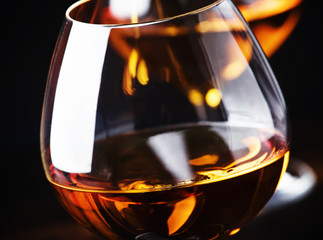 Cognac in a glass, dark background, selective focus