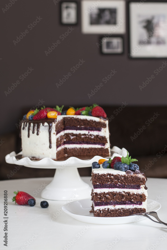 Poster Festive chocolate cake with berry jelly, creamcheese and chocolate stains in home interior.