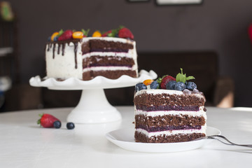 Festive chocolate cake with berry jelly, creamcheese and chocolate stains in home interior. Homemade.