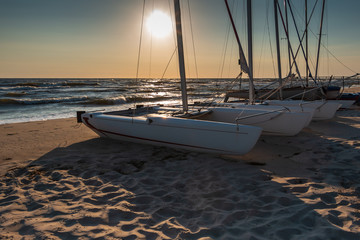 Yacht - Katamaran am Strand bei Sonnenuntergang. Yachting, Luxus-Segeln. Insel Usedom, Ostsee,...