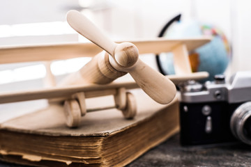beautiful handmade wooden toy-plane on a book with globe on the background