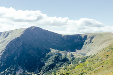 Obraz premium Zalesiony stok górski w nisko leżącej chmurze z wiecznie zielonymi iglakami owiniętymi mgłą w malowniczym krajobrazie