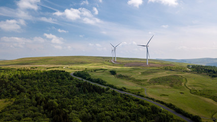 Fototapeta na wymiar Aerial view of large wind turbines on a rural hillside in Wales