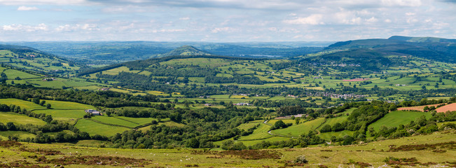 Panoramic aerial view of green farmland and fields in the rural Welsh countryside