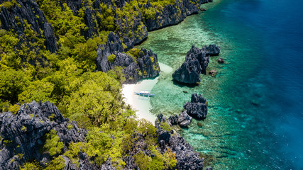 Aerial drone view of spectacular tropical scenery with towering cliffs, jungle and pristine sandy beaches