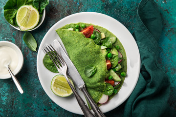green spinach crepes with vegetables for breakfast