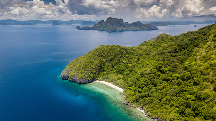 Aerial drone view of a beautiful rugged tropical archipelago with jagged cliffs and sandy beaches