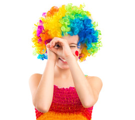 Cute little girl in colourful clown loooking through her hands like binocular, isolated on white backgrond