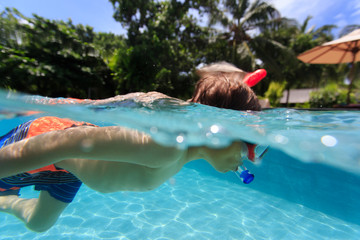little boy swim underwater with mask