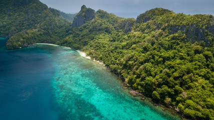 Aerial drone view of the tropical beaches and jungle of Cadlao Island, El Nido, Philippines