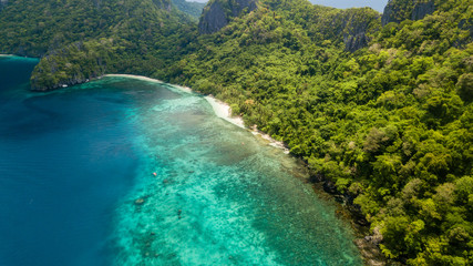 Aerial drone view of the tropical beaches and jungle of Cadlao Island, El Nido, Philippines