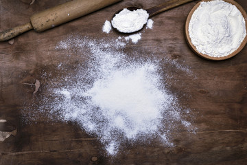 scattered white wheat flour on a brown wooden surface