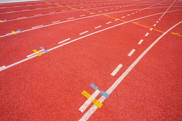White lines of stadium and texture of running racetrack red rubber racetracks in outdoor stadium are 8 track and green grass field,empty athletics stadium with track,football field, soccer field.