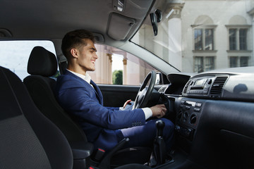 Smiling businessman sits insde the car