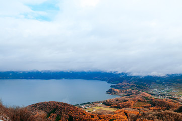 Hokkaido Usuzan mountain forest and lake Toya in urly winter with autumn foliage yellow tree, aerial view