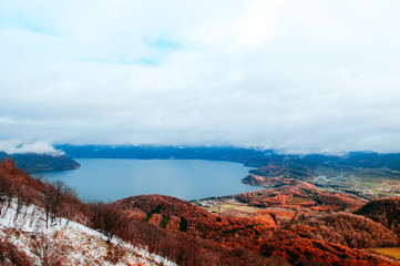 Hokkaido Usuzan mountain forest and lake Toya in urly winter with autumn foliage yellow tree, aerial view