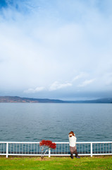 Fototapeta premium Japanese woman standing by lake Toya shore with Nakajima island view, Hokkaido