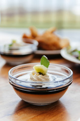 Creamy vanilla caramel pudding with Kiwi in glass cup and coffee on wood table
