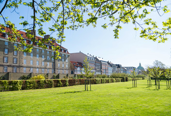 beautiful green lawn with bushes and old buildings in copenhagen, denmark