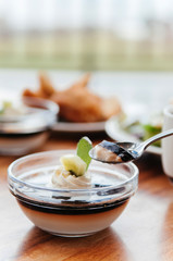Creamy vanilla caramel pudding with Kiwi in glass cup on wood table