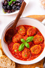 Baked mini meatballs in tomato sauce with basil