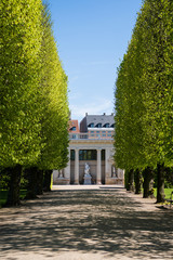 Obraz premium alley with green trees and beautiful building with columns and sculptures in copenhagen, denmark
