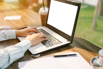 Close-up of business female working with laptop make a note document and smartphone in coffee shop like the background.