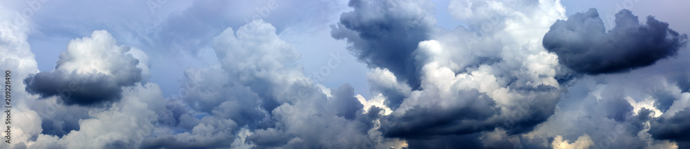 Wall mural gray rainy sky with big clouds.
