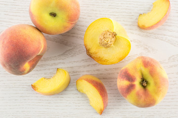 Yellow peaches flatlay collection on grey wood background.