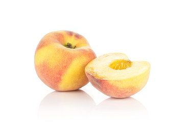 One yellow peach and a half without drupe isolated on white background.