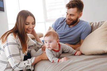 Obraz premium Happy young family. Parents having fun with their little child