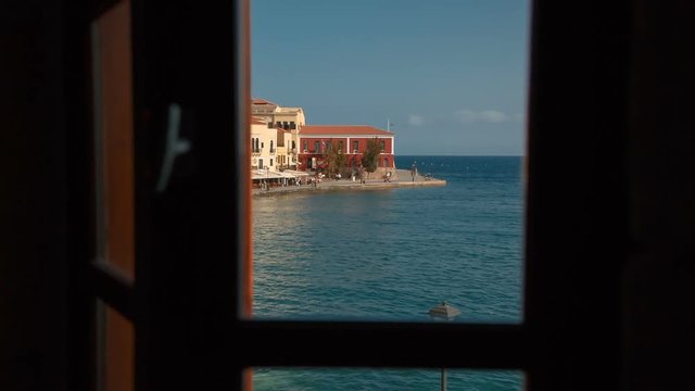 Inspirational shot of a window opening to a spectacular view of the seafront of Chania, Crete, Greece