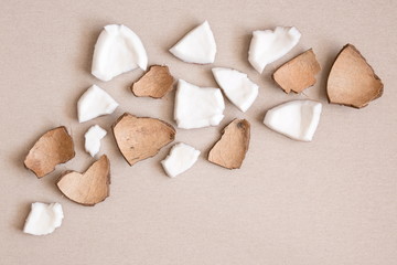 Pieces of coconut on a linen background. Flat lay, top view, copy space 