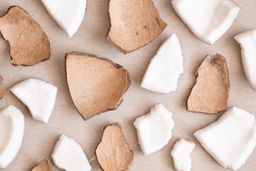 Pieces of coconut on a linen background. Flat lay, top view, copy space 