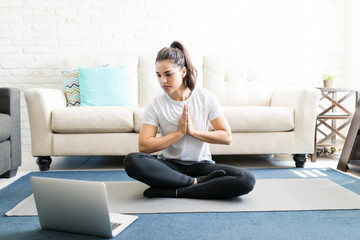 Woman repeating exercises while watching online workout session