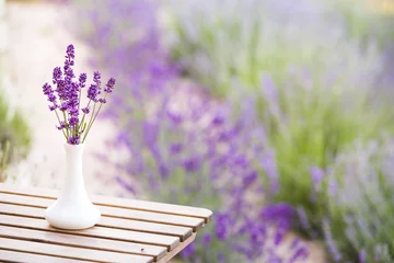 Poster Lavender flower composition on field with vase and basket. Sunset gleam over purple flowers of lavender. Provence region of france. © Kotkoa