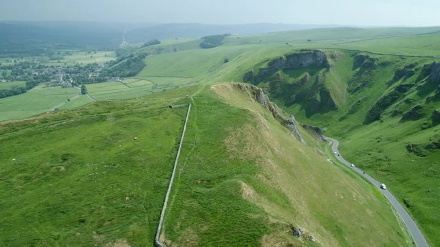Long winding road between two scenic  Hills on a sunny day with dark clouds in background 1