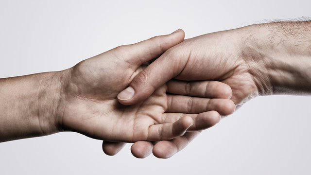 Concept of salvation. Image of hands of two people at the time of rescue (help).