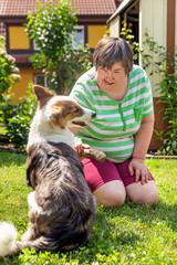 Frau mit geistiger Behinderung und ein Hund im Garten, Hilfe durch Therapiehund