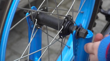 Young boy repairing bicycle wheel with tools