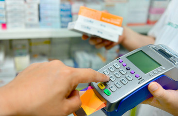 Buyer in pharmacy drugstore, a customer paying with a credit card and using a terminal.insurance concept.