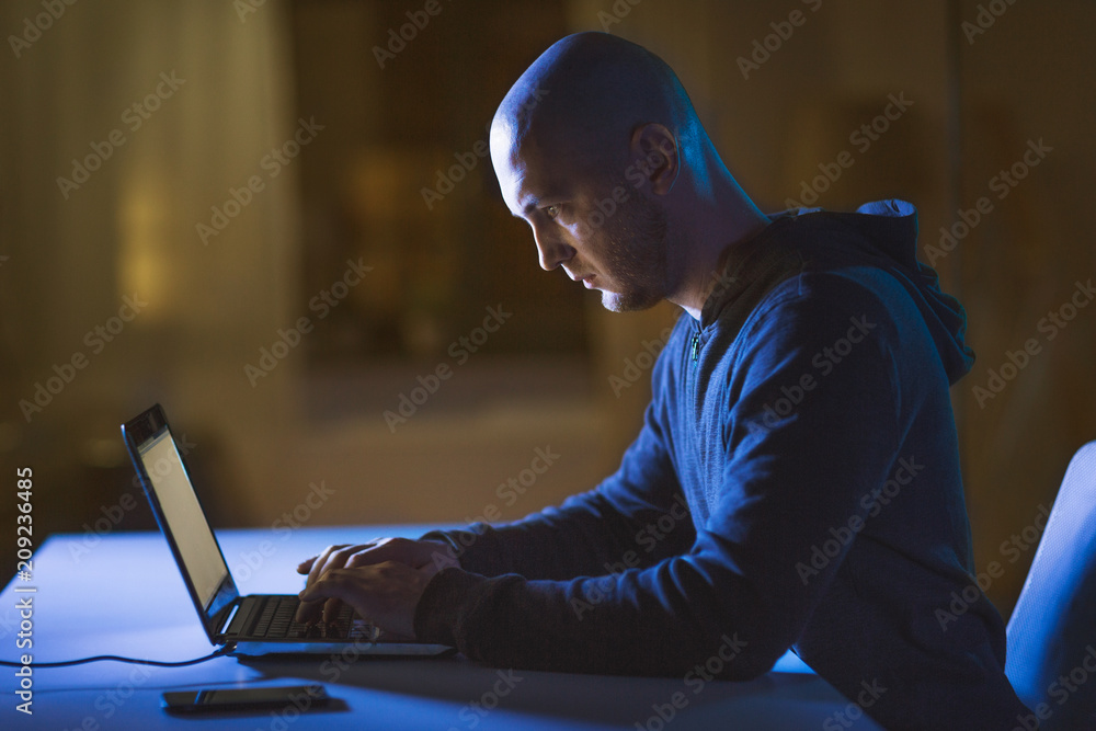 Aufkleber cybercrime, hacking and technology crime - male hacker in dark room using laptop computer for cyber 