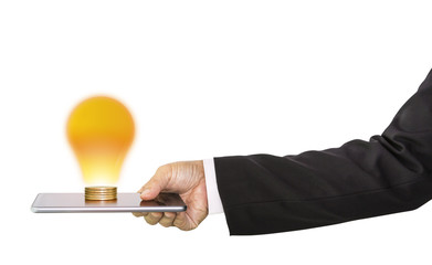 Businessman hand holding mobile phone and stack of money coins with light bulb ideas on top on white background; concept of financial planning and technology