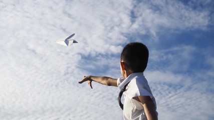 Asian school boy playing with paper airplane.(Selected focus)