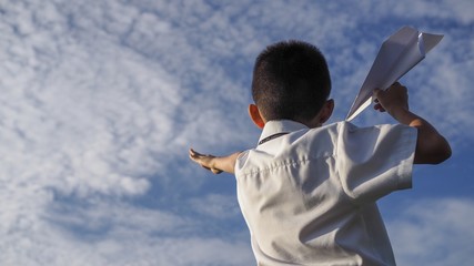 Asian school boy playing with paper airplane.(Selected focus)