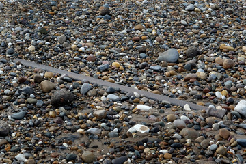 Parts of British world war two rp3 3 inch rocket projectile on a beach used as a practice firing range.