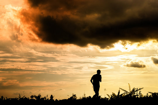 Silhouette of a man  jogging for exercise in park at sunset,Silhouette  sporty image concept.