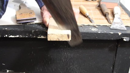 Carpenter cutting wooden plank