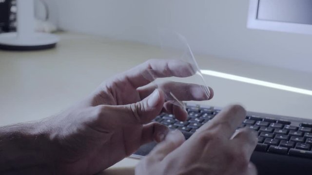 Man's Hand With A Transparent Foil, Suitable As Transparent Flexible Future Mobile Phone Made Of Graphene. Single-layer Carbon Foil